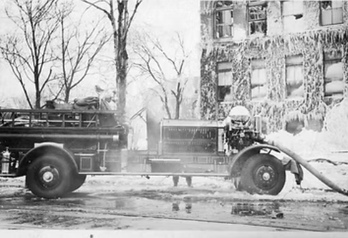 A fire truck with a fireman on the backAI-generated content may be incorrect.